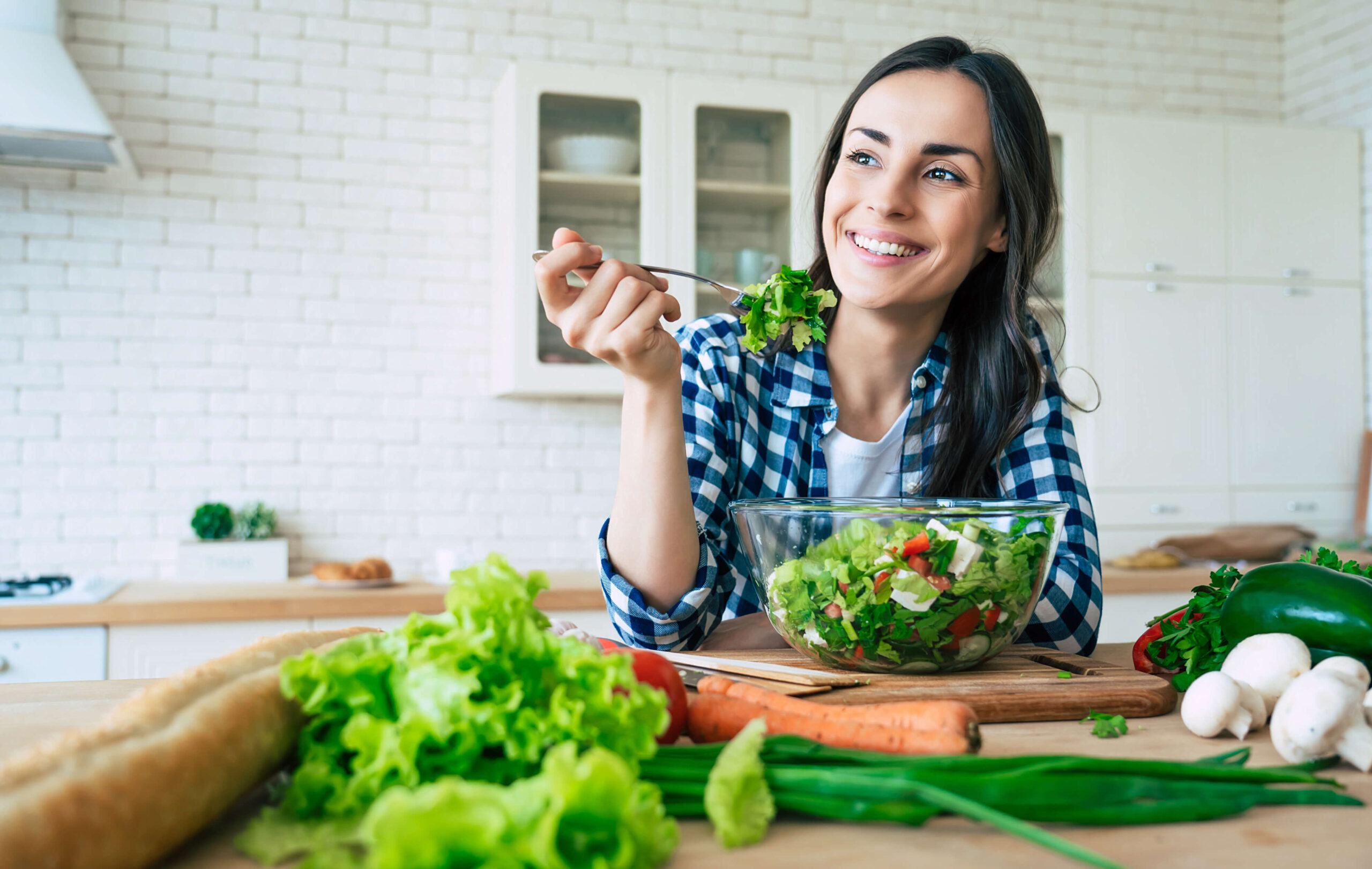 donna-che-mangia-insalata-con-verdure-sul-tavolo
